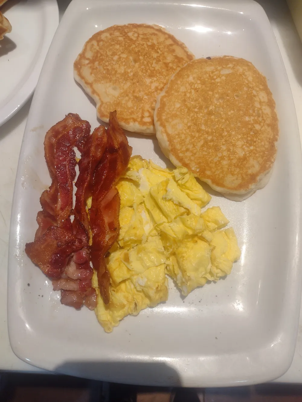 Pancakes with scrambled eggs and bacon