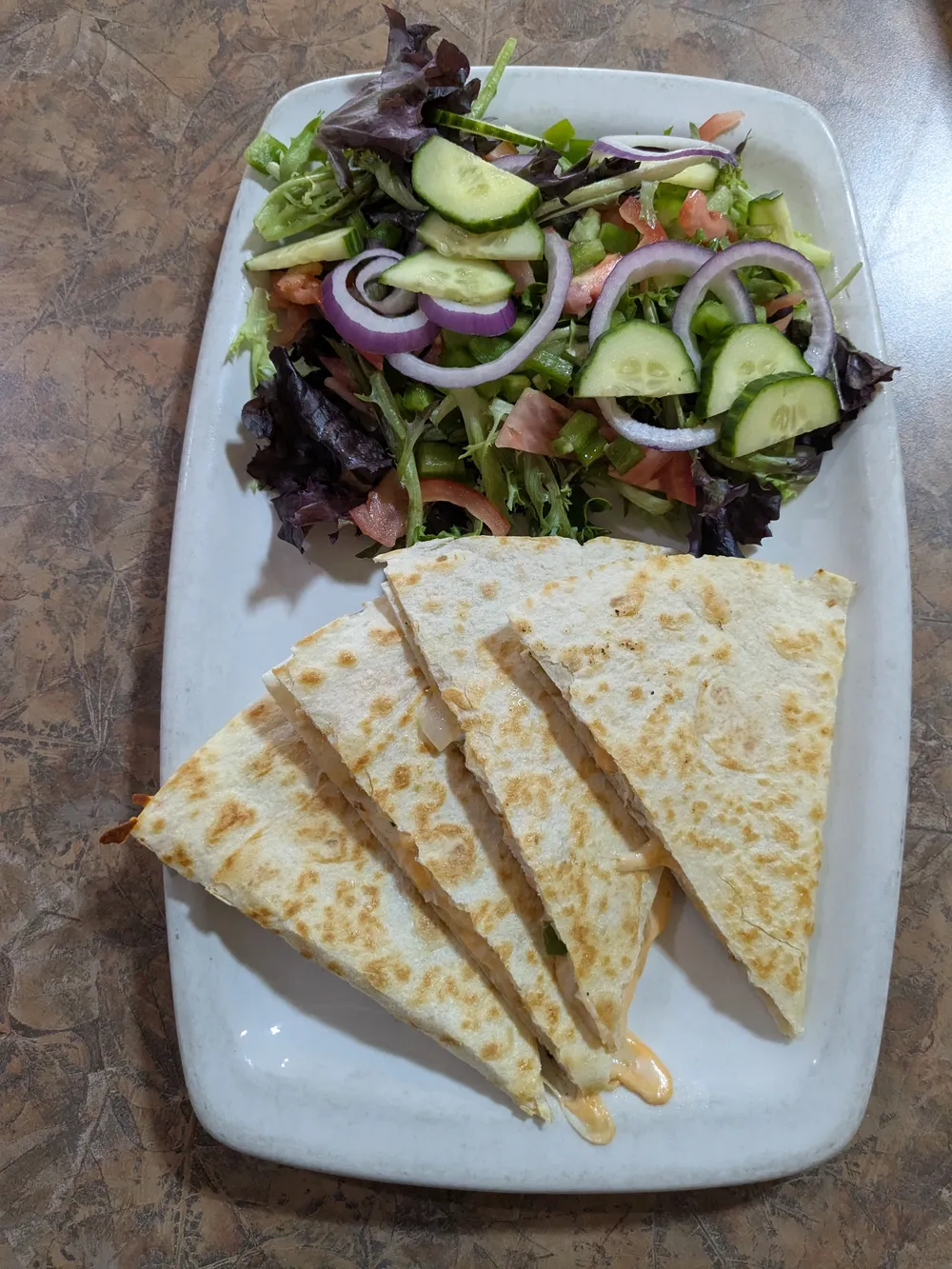 A quesadilla with a side salad