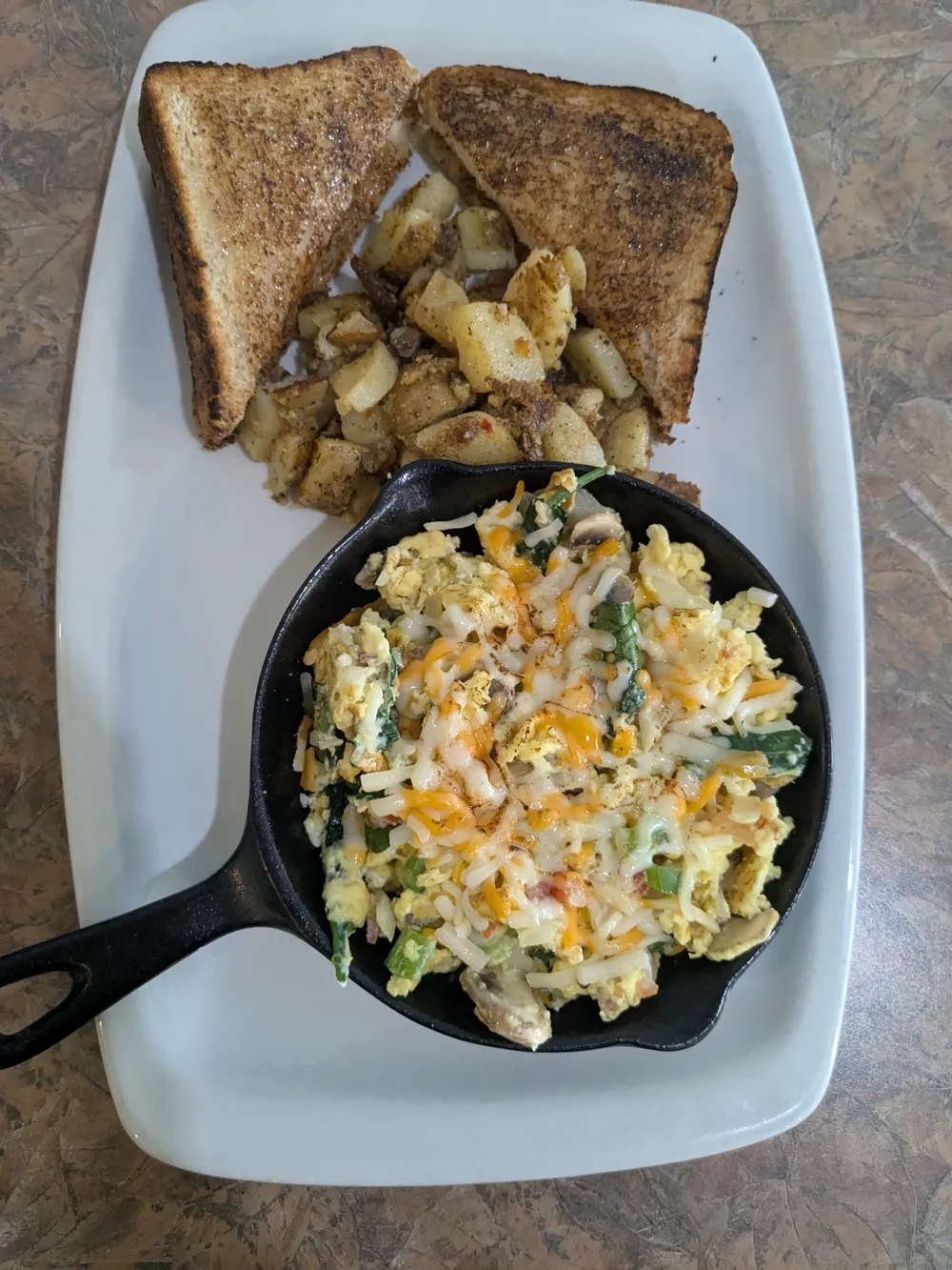 A cast-iron skillet of scrambled eggs and peppers